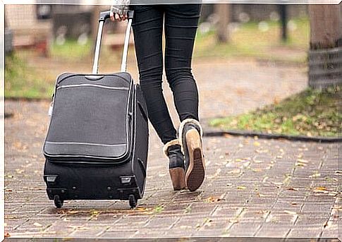 Woman in boomerang generation carries suitcase