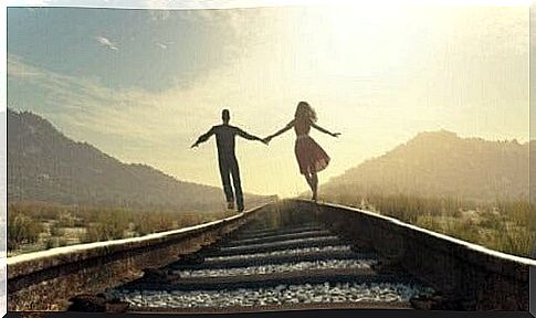 A couple walking on the train tracks.