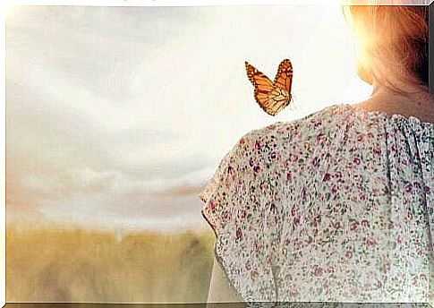 Woman with butterfly on shoulder symbolizing one of the 10 laws of abundance