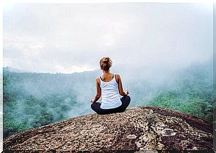 A woman meditating on a mountain