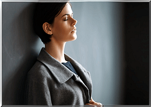 Woman leaning against the wall.