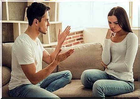 A couple is sitting on the couch arguing about a problem