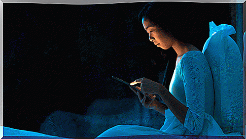 Woman in bed with cell phone