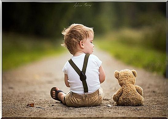 little boy sitting on a path