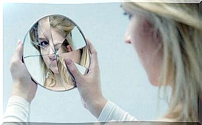 Woman looking in a broken mirror.