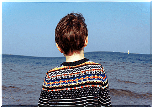 A grieving child looking out to sea.