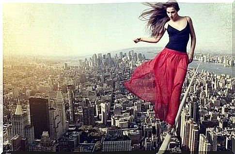 Woman with red skirt balancing on line over a city