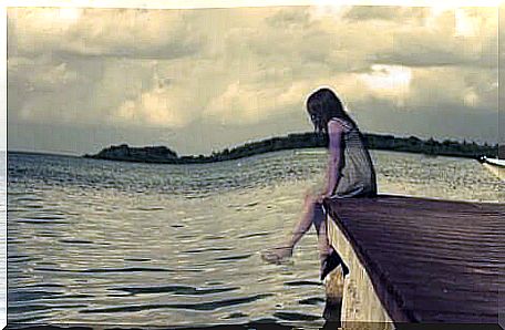 A girl sitting on a pier