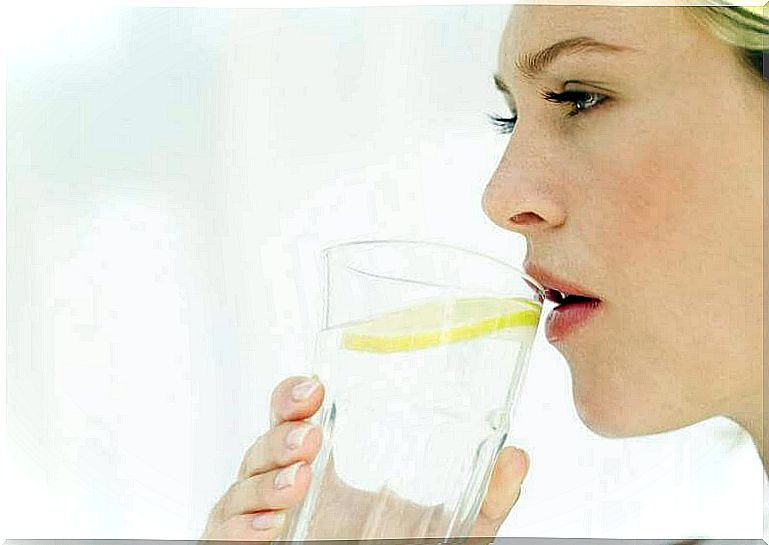 Woman drinking hot water with lemon