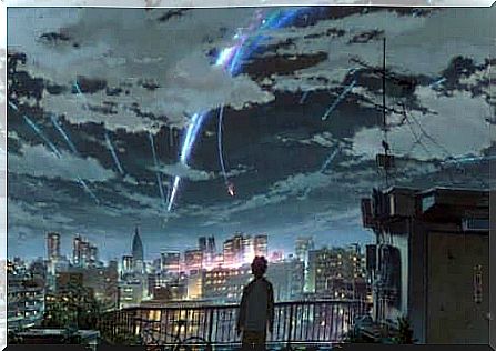 A young person looking over a city that appears to have meteors falling from the sky.